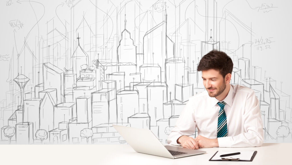 Businessman sitting at the white table with hand drawn buildings